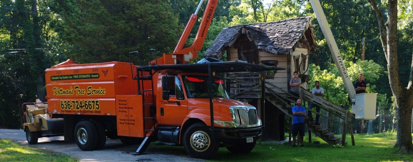 The Kottman's crew with the orange Treeman bucket truck and chipper on a job